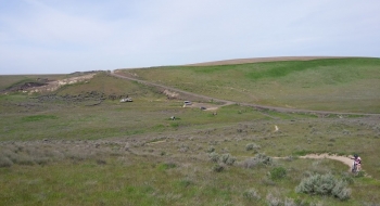 Parking area, as seen looking west from the trail. You drive in from over the hill on the road seen above the cars.