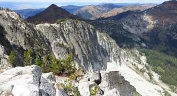 Cliffs on the north side of Granite Butte with Burger Butte and China Cap in the background.