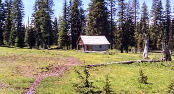 The trail comes into this meadow to the right of Standley Guard Station in this picture.