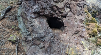 Some type of man-made hole in the rocks near the bottom of the trail. 