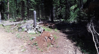 Post with no sign for Fake Creek Trail (right).